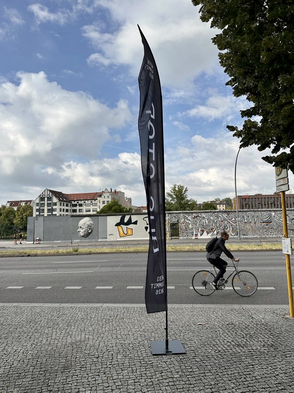 Web3 Summit shuttle bus pick-up flag at the bus stop next to Hotel Indigo and Hampton by Hilton on East Side Gallery